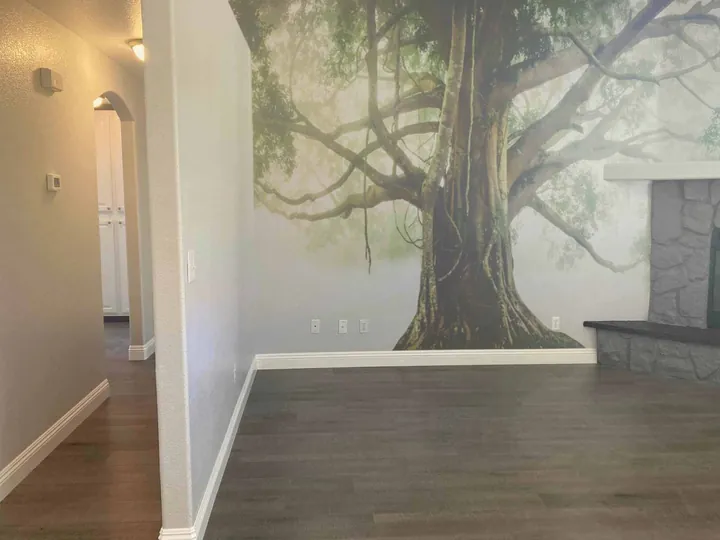 Large realistic tree mural painted across a residential feature wall