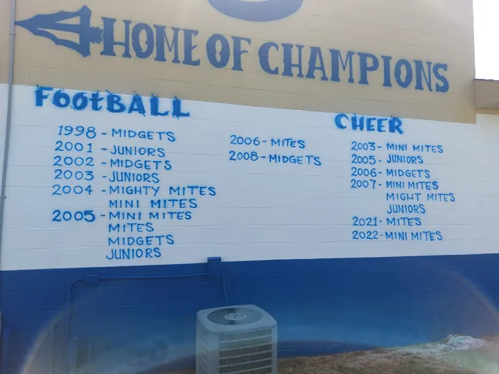 School exterior champions wall mural listing football and cheer achievements