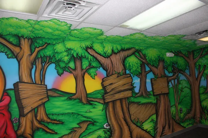 Colorful woodland cartoon mural wrapping an interior room with trees and signs