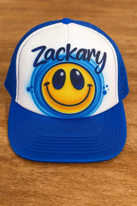 Blue and white trucker hat with Zackary name and smiling face airbrush design